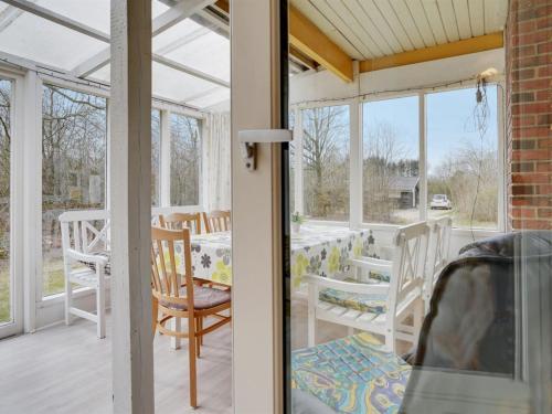 a screened porch with chairs and a table at Holiday Home Hejne - 29km from the sea by Interhome in Toftlund