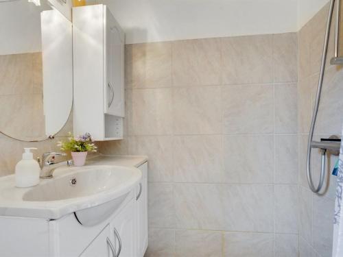 a white bathroom with a sink and a mirror at Holiday Home Hejne - 29km from the sea by Interhome in Toftlund