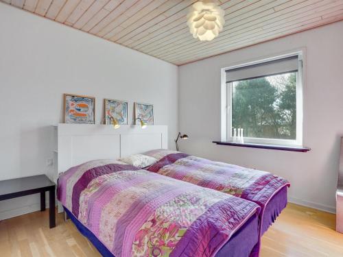 a bedroom with a large bed and a window at Holiday Home Ewelina - 15km from the sea by Interhome in Ballum