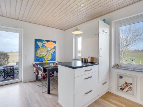 a kitchen with white cabinets and a desk and a window at Holiday Home Ewelina - 15km from the sea by Interhome in Ballum