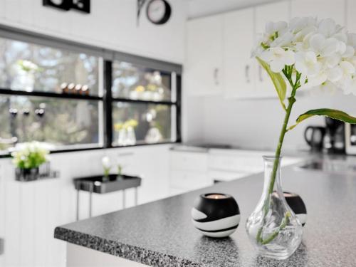 a vase with white flowers sitting on a counter at Holiday Home Elisabeta - 28km from the sea by Interhome in Toftlund