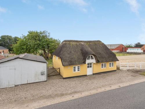 a yellow house with a thatched roof on the side of a road at Holiday Home Miko - 19km from the sea by Interhome in Skærbæk