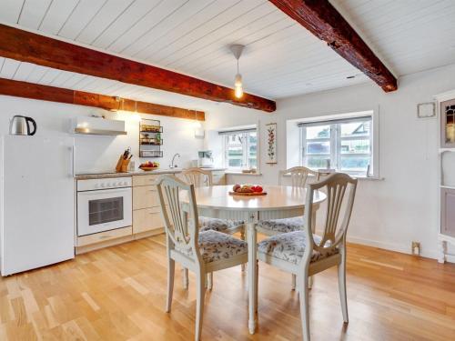 a kitchen with a table and chairs and a refrigerator at Holiday Home Miko - 19km from the sea by Interhome in Skærbæk