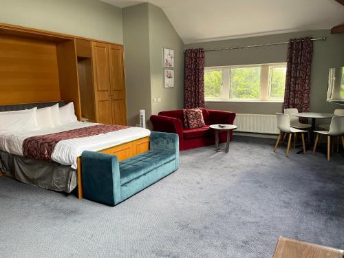 a hotel room with a bed and a table and chairs at Skipton Hotel - formerly known as Hotel Rendezvous-Skipton in Skipton