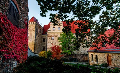 an old castle with red roofs and trees at Uroczysko Siedmiu Stawów Spa by L'Occitane in Gola Dzierżoniowska