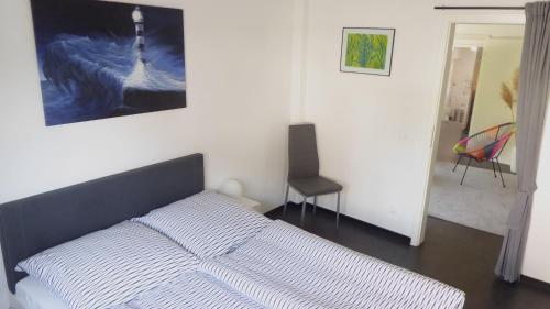 a bed in a bedroom with a painting on the wall at Ferienwohnung Sofie Marie in Oberhausen