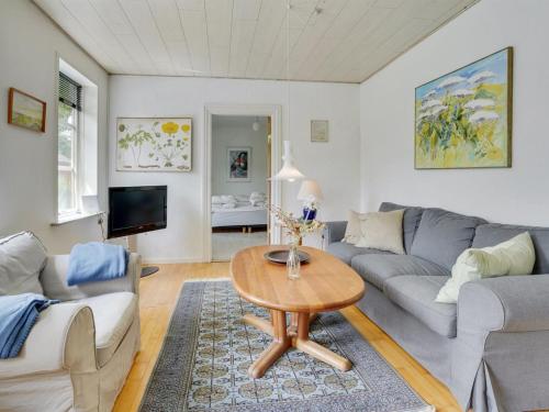 a living room with a couch and a table at Holiday Home Jonni - 15km from the sea by Interhome in Skærbæk