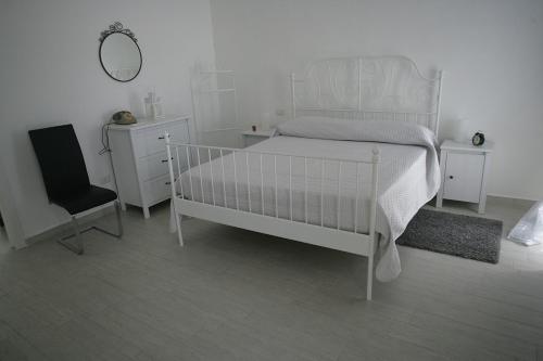 um quarto branco com uma cama e uma cadeira em Il Portale em Terlizzi