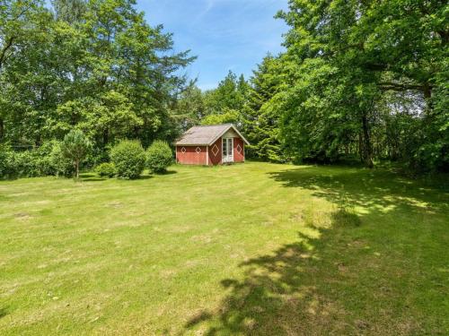 a small red house in a field with trees at Holiday Home Jonni - 15km from the sea by Interhome in Skærbæk