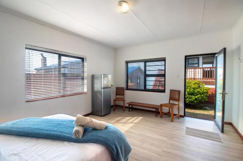 ReebokにあるOceanfront beach house, Reebok, Garden Routeのベッドと2つの窓がある寝室