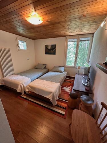 a bedroom with two beds and a wooden ceiling at Ca'Mugo, a chalet in the magic woods, near Cortina in Vodo Cadore