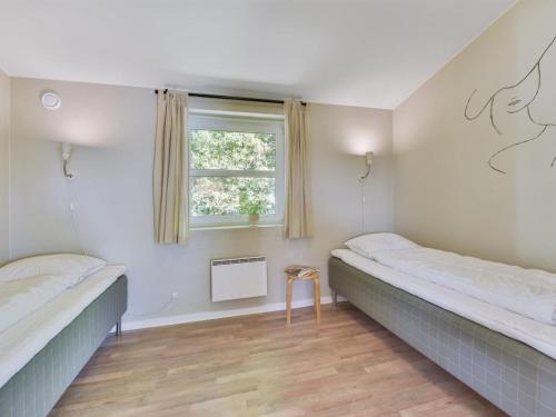 two beds in a room with a window at Holiday Home Najdenka - 25km from the sea by Interhome in Toftlund