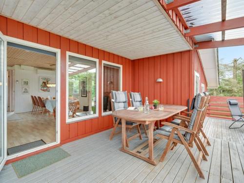 a patio with a wooden table and chairs on a deck at Holiday Home Anline - 900m to the inlet by Interhome in Tarm