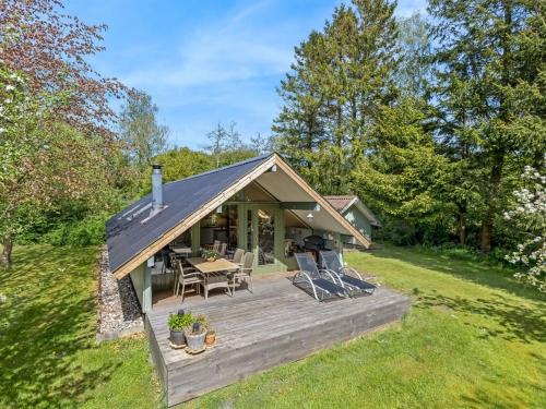 a cabin with a wooden deck in the grass at Holiday Home Hilla - 31km from the sea by Interhome in Toftlund