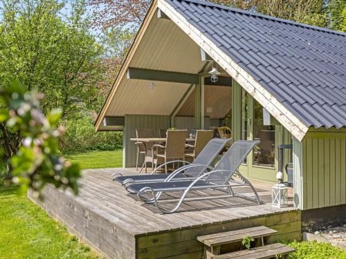a deck with chairs and a table in front of a house at Holiday Home Hilla - 31km from the sea by Interhome in Toftlund