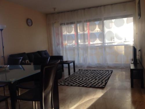 a living room with a table and chairs and a window at Apartment on Nitza 8a in Netanya