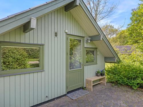 a green house with a bench in front of it at Holiday Home Hilla - 31km from the sea by Interhome in Toftlund