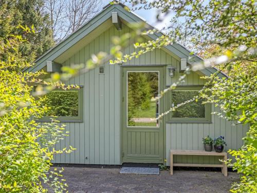 a green shed with a window and a bench at Holiday Home Hilla - 31km from the sea by Interhome in Toftlund