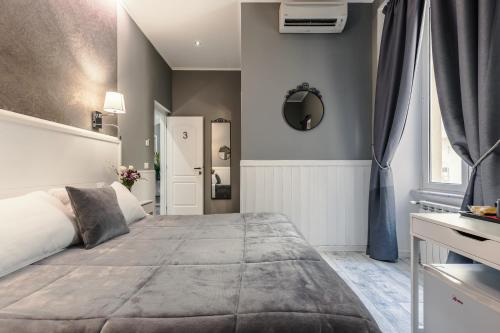 een slaapkamer met een groot bed en een spiegel bij Bed And Best in Rome