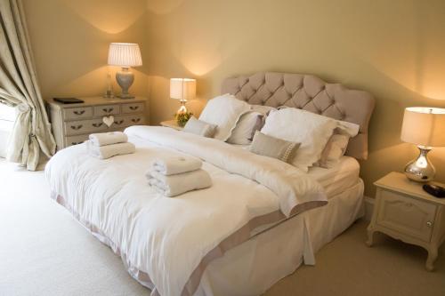 a bedroom with a large white bed with towels on it at Newton Farmhouse B & B in Jedburgh
