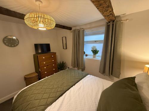 a bedroom with a bed and a window at The Whitchurch Apartment- The Painted Rooms in Whitchurch