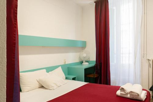 a bedroom with a bed with a blue and red canopy at Hôtel De La Gare Nantes Station Hotel Nantes in Nantes
