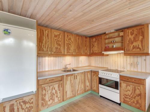 a kitchen with wooden cabinets and a white stove top oven at Holiday Home Jaane - 650m to the inlet by Interhome in Hemmet
