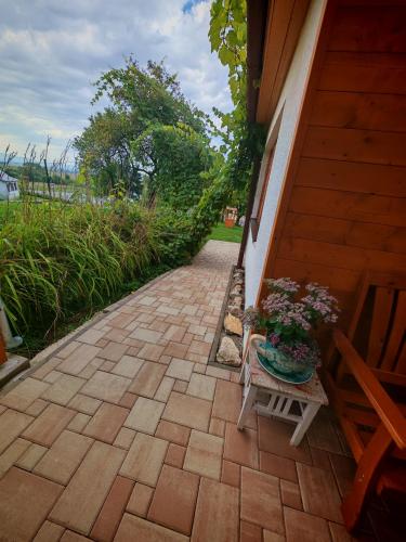 a patio with a table and a bench and flowers at Ondrašovská skala in Ondrašová