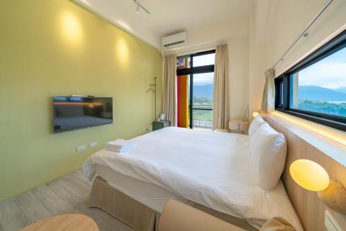 Un dormitorio con una cama grande y una ventana grande. en 冉冉七星潭海景民宿, en Xincheng