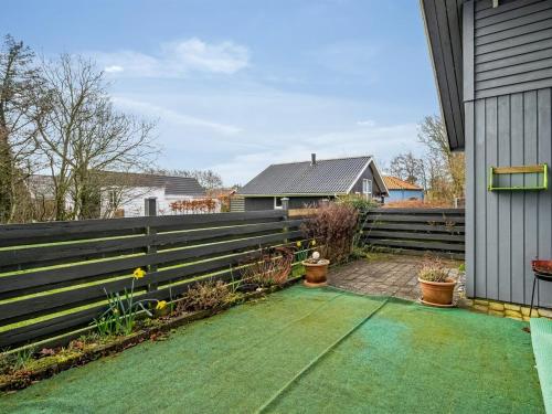 ein Hinterhof mit einem Zaun und einem grünen Rasen in der Unterkunft Holiday Home Remo - 990m to the fjord by Interhome in Hemmet