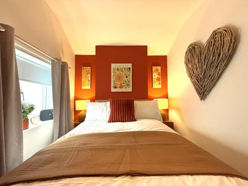 a bedroom with a large bed with a heart decoration on the wall at The Whitchurch Apartment- The Painted Rooms in Whitchurch
