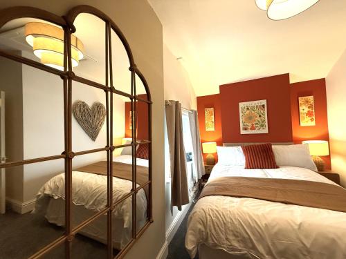 a bedroom with a bed and a large mirror at The Whitchurch Apartment- The Painted Rooms in Whitchurch