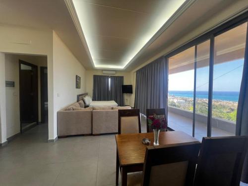 a living room with a couch and a bed and a table at Amchit Grand Hotel in Al Qarfī