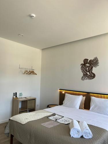 a bedroom with a bed with two towels on it at Palacium Charming Suites in Figueiró dos Vinhos