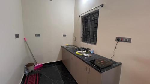 a small kitchen with a sink and a window at Garden Homestay in Yelagiri