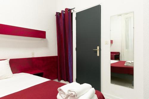 a bedroom with a red and white bed and a mirror at Hôtel De La Gare Nantes Station Hotel Nantes in Nantes