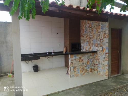 a kitchen with a counter with tiles on the wall at Chacaras Leos in Arapiraca