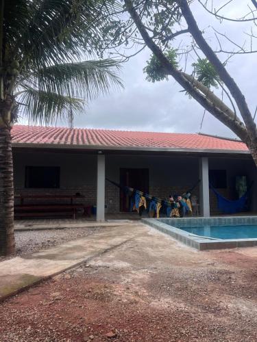a building with a swimming pool next to a house at Chacaras Leos in Arapiraca