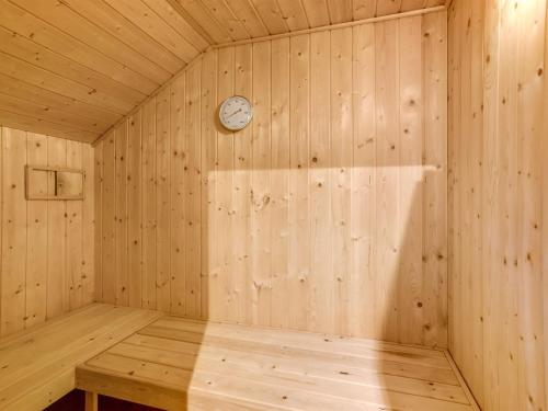 a wooden sauna with a clock on the wall at Holiday Home Tecla - 12km from the sea by Interhome in Oksbøl