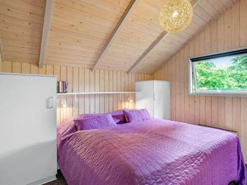 a bedroom with a purple bed in a room at Holiday Home Tecla - 12km from the sea by Interhome in Oksbøl