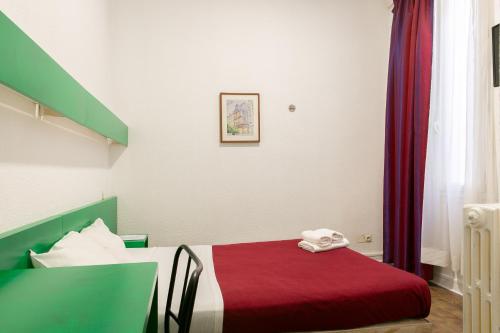 a small room with a bed with a red blanket at Hôtel De La Gare Nantes Station Hotel Nantes in Nantes