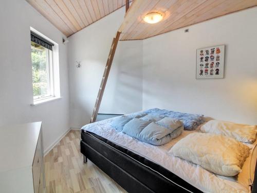 a bed in a room with a ladder at Holiday Home Jani - 25km from the sea by Interhome in Toftlund