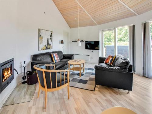 a living room with black leather furniture and a fireplace at Holiday Home Jani - 25km from the sea by Interhome in Toftlund