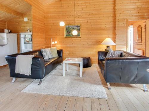 Una sala de estar con dos sofás de cuero y una mesa. en Holiday Home Ulvi - 300m to the inlet by Interhome, en Skjern