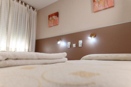 a bedroom with two beds with white towels on them at Pensión Discoves in Pinseque
