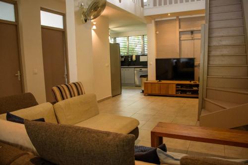 Una sala de estar con un sofá y un televisor. en Eden Sea Villa, en Pointe-Noire