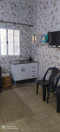 a kitchen with a chair and a dresser in a room at Flat a 4 minutos da basílica in Aparecida
