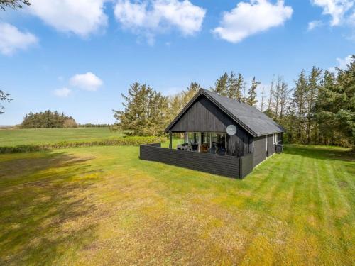 a small black building in a field with trees at Holiday Home Aleida - 100m to the inlet by Interhome in Vemb