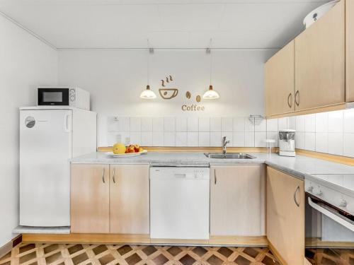 a kitchen with a white refrigerator and a sink at Apartment Gertraude - 17km to the fjord by Interhome in Skjern