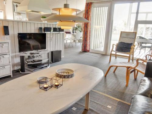 un soggiorno con un tavolo e una TV di Holiday Home Kody - 350m to the fjord by Interhome a Ulfborg